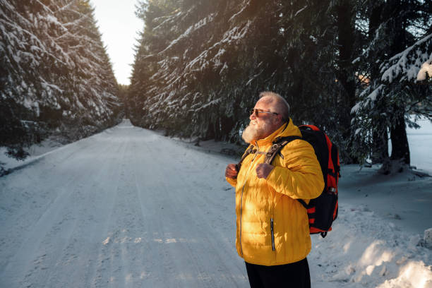 istock Senior man trail hiking on snowy mountain 1982067891