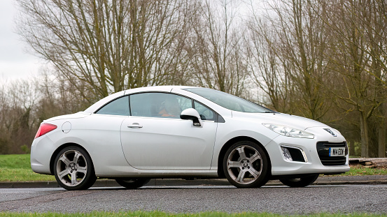 Milton Keynes,UK- Feb 2nd 2024: 2012 Peugeot Allure 308  car driving on an English country road.