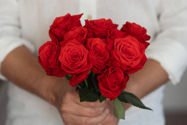 istock Man holding a bunch of roses 1982158203