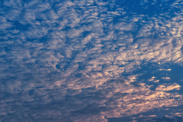 Beautiful waves of clouds against bright blue sky.