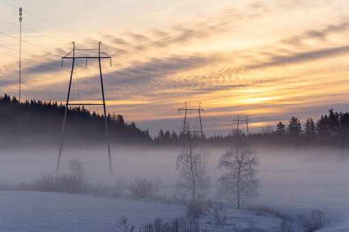 Power towers and electric wires at hazy winter scenery