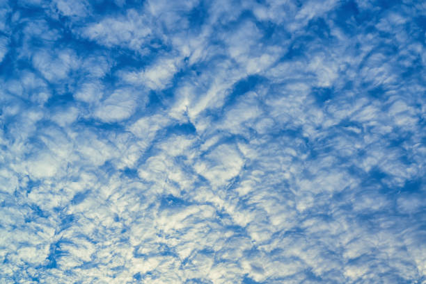 Beautiful waves of clouds against bright blue sky.