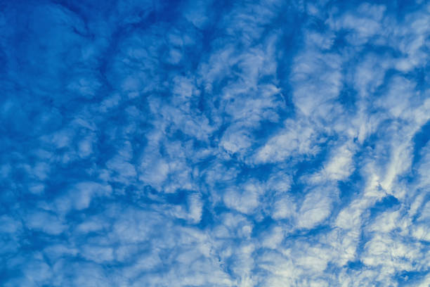 Beautiful waves of clouds against bright blue sky.