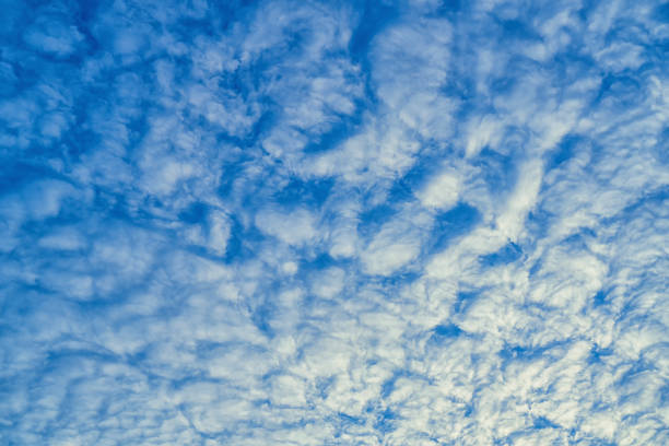 Beautiful waves of clouds against bright blue sky.