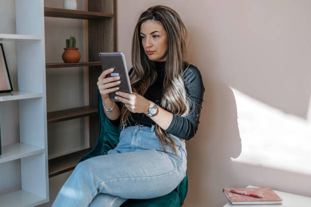 istock The beautiful woman sitting on the chair and using a digital tablet. 1982207145