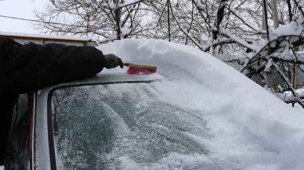 istock brushing the car against snow drifts 1982214548