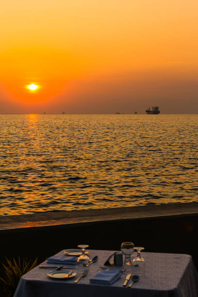 istock Amazing romantic dinner tables in outdoors beach restaurant. Vacation, honeymoon romance love, luxury destination dinning, exotic table setup with sea view 1982241538