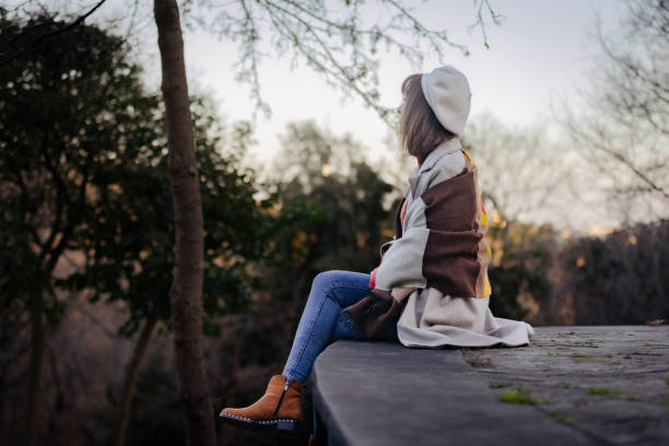 istock Elegance woman is spending time at public park in autumn. 1982258410