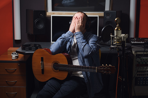 A crying musician in a recording studio. The workplace of a sound engineer in a recording studio