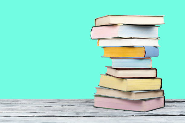 istock Open stacking book, hardback colorful books on wooden table and green background. Back to school. Copy space for text. Education business concept. 1982305406