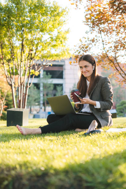istock Caucasian woman in jacket using laptop in public park, using internet everywhere. Lifestyle concept 1982307052