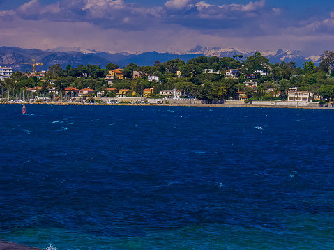 The chic resort of Juan-les-Pins is known for its long, sandy beaches and seafront promenade lined with smart outdoor eateries and fashion boutiques, overlooked by modern apartment buildings. Alpes Maritime Côte d'Azur Provence South of France.