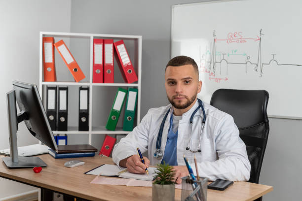 istock Young doctor or e general practitioner physician work in patient files at office medical clinic 1982352403
