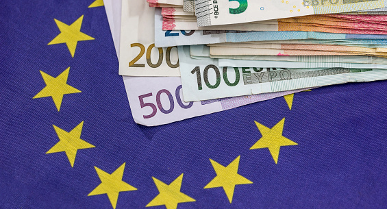 euro paper bills on national European flag in the background. Finance economy concept