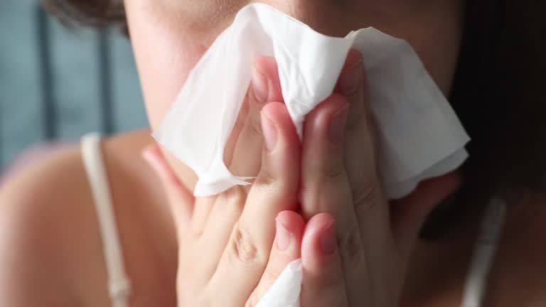 Ill upset young woman wiping nose with tissue. Health problems, cold and flue symptoms concept