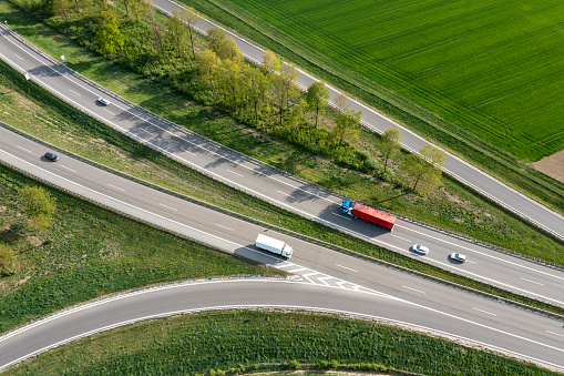 Aerial view of a rural highway junction with cars and trucks.