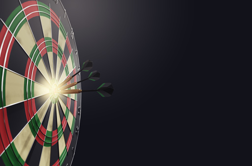 A dart hitting the center of target with cloud sky background, concept of winner, business success