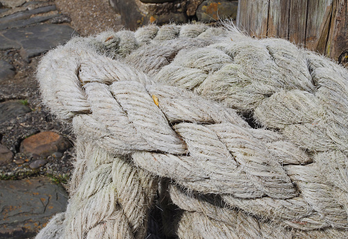 Thick white fishing rope on quayside in fishing village in Devon, UK