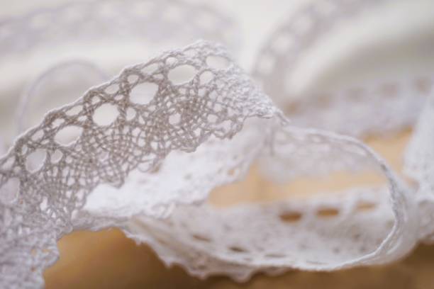istock Closeup view tender white lace tape on brown table 1982429662