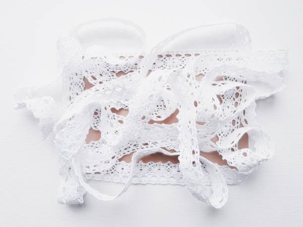 istock Soft white lace tape top view on brown and white surface 1982429671