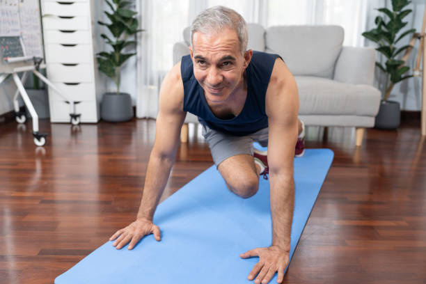 istock Athletic and active senior man doing plank climbing at home. Clout 1982459624