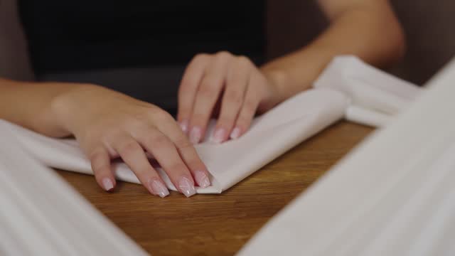apprentice folding white napkins in restaurant