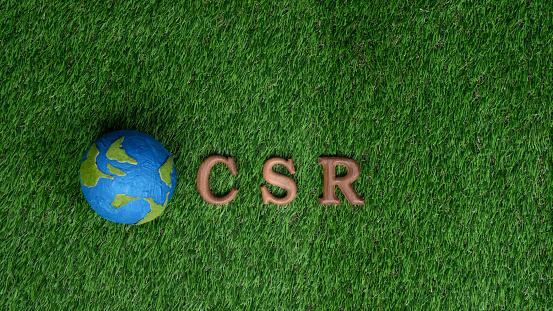 Arranged wooden alphabet text in CSR on biophilic background with Earth planet sign as eco symbol for corporate social responsible with net zero and environmental campaign for greener community. Gyre