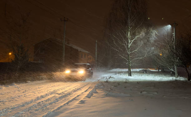 istock A car drives through white snow at night 1982472489