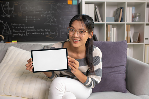 Young Asian teacher transforms her living space into an engaging online classroom,  teaching online with passion, concept of online teaching and education.