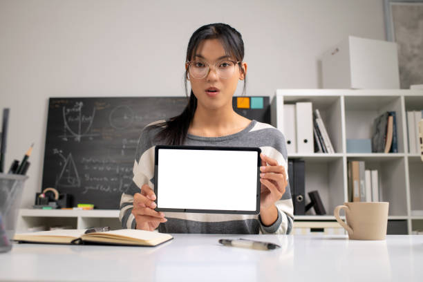 istock Young Asian teacher transforms her living space into an engaging online classroom,  teaching online with passion, concept of online teaching and education. 1982478477
