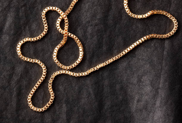 istock Gold chain on black silk fabric. Close-up 1982479955