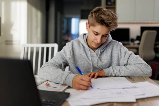 istock Teenage boy doing homework 1982488826