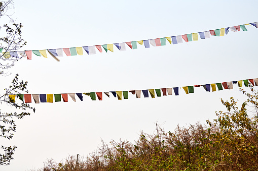 Street multicolored decorations, streamers in the wind, close-up view, clear blue sky background . Galicia, Spain.