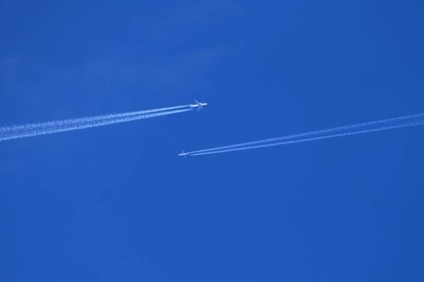 istock Airplanes in the blue sky with contrail 1982506498
