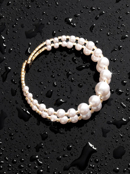 istock Women's bracelet in drops of water on a black background 1982506504