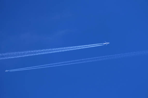 istock Airplanes in the blue sky with contrail 1982506508