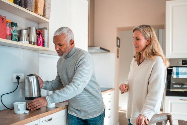 istock Diverse Senior Couple Preparing Coffee in Kitchen 1982512121