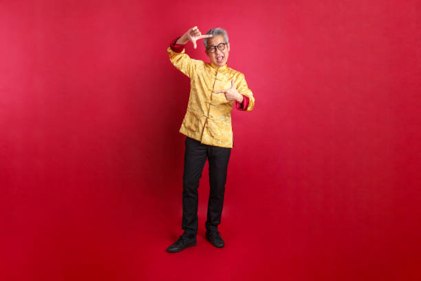 A senior Asian man is doing his make-up - gearing ready for Chinese Opera performance.