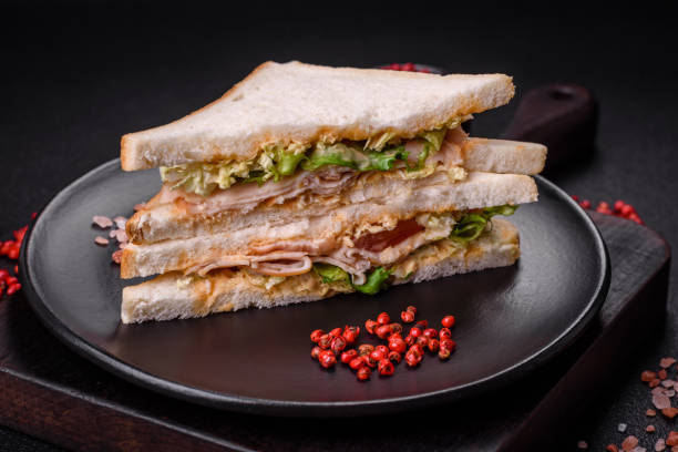 istock Delicious nutritious sandwich with toast bread, ham, tomatoes, cheese and sauce 1982580965