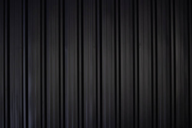 istock black corrugate wall background and texture,vertical black metal fence panel with light and shadow. 1982585193