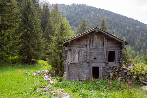 Wooden shed in Binnatal in the Swiss Alps along a mountain trail.