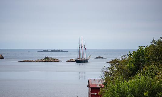 Large wooden sail ship leaving a fjord