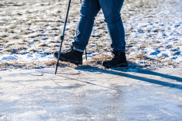 istock Person walking on ice with spikes and walking poles. 1982619598
