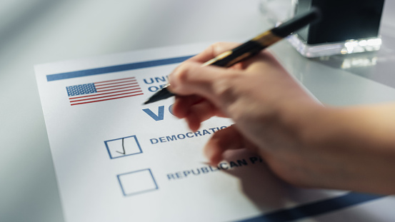 Close Up View on an Anonymous Person Filling Out a Ballot in a Voting Booth on the Day of National Elections in the United States of America. Man or Woman Choosing to Vote for Democratic Party
