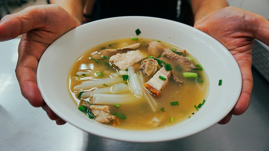 Tom Kuay Jap clear soup, Thai Street Food Menu. Paste of Rice Flour or Boiled Chinese Pasta Square with Crispy Pork. Crispy pork soup is a primarily liquid food, generally served warm or hot, that is made by combining ingredients such as meat and vegetables with stock.