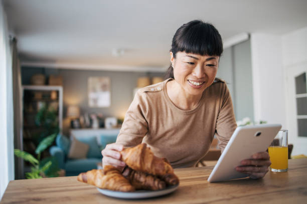 istock Middle age Japanese woman watching something on her digital tablet 1982639062