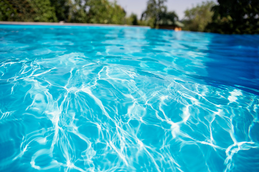 Beautiful blue water in swiming pool with sun reflection