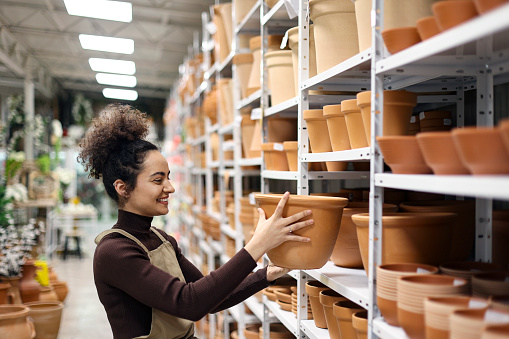 Young woman working in a store. About 25 years old mixed-race female.