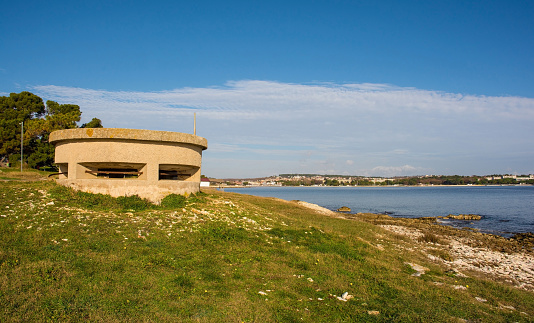 A World War Two bunker on the coast of the Kasteja Forest Park - Park Suma Kasteja - in Medulin, Istria, Croatia. Medulin town is in the background. December