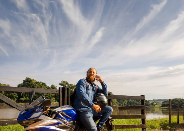 Photo of a man and his motorcycle in a rural place.Freedown.